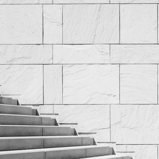 a set of stairs leading up to a white brick wall .