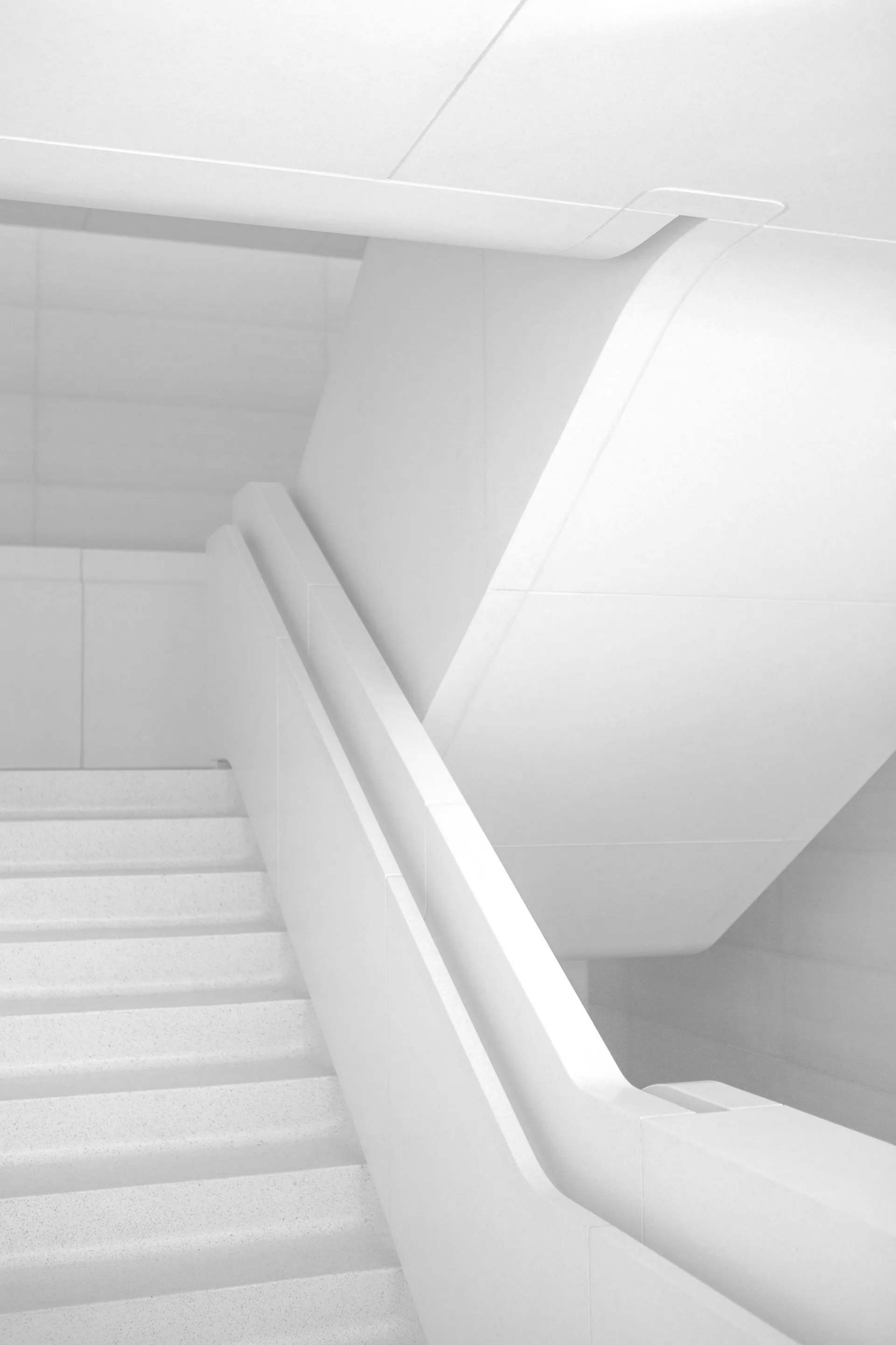 a white staircase with a white railing in a building