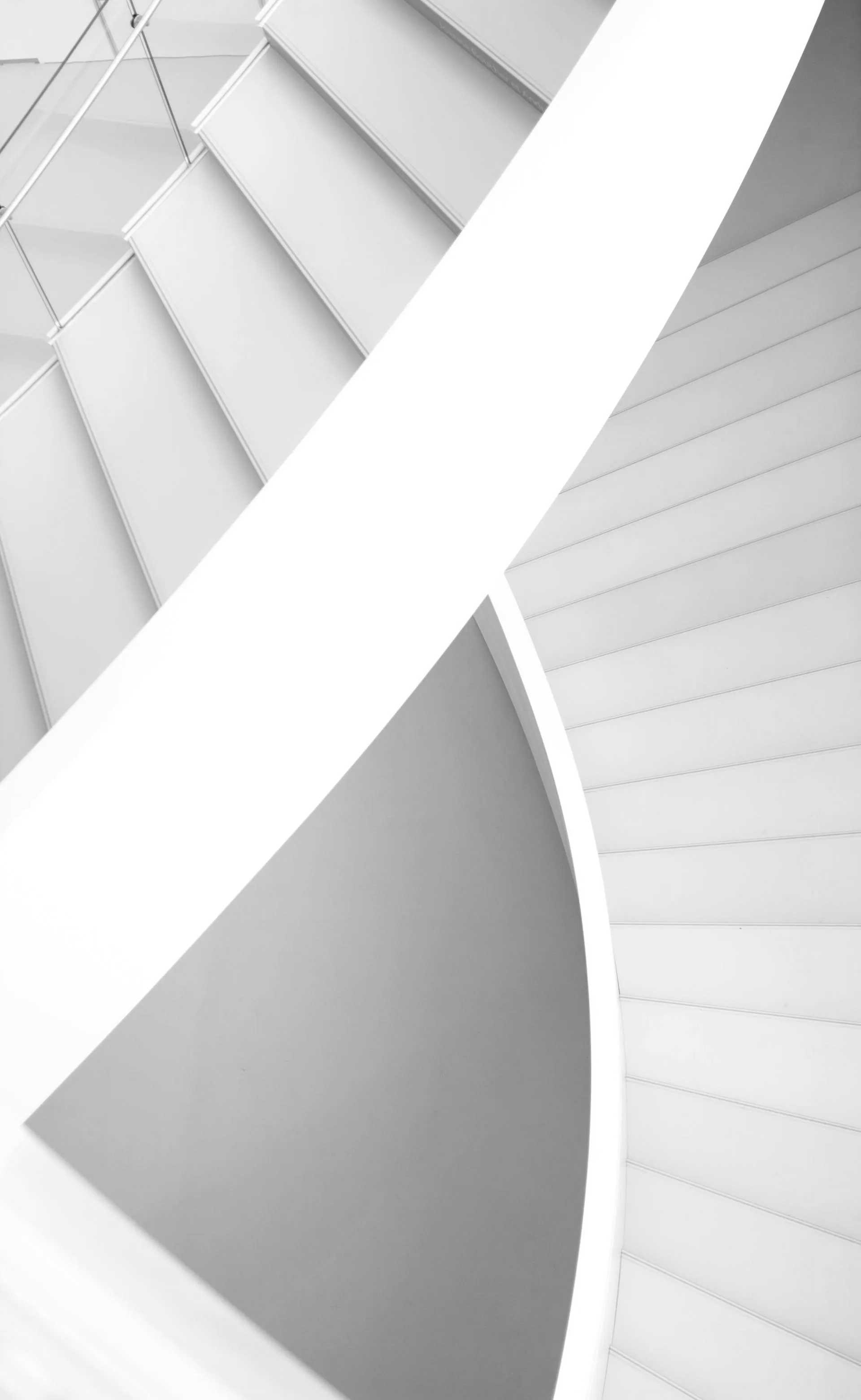 a black and white photo of a spiral staircase in a building .
