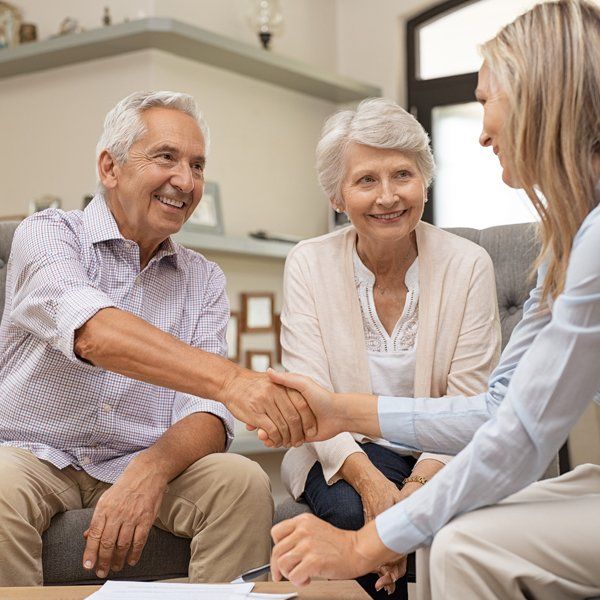 Senior Couple Shaking Hands With Financial Advisor — Wilmington, DE — S.M.A.R.T Tax Free Retirement