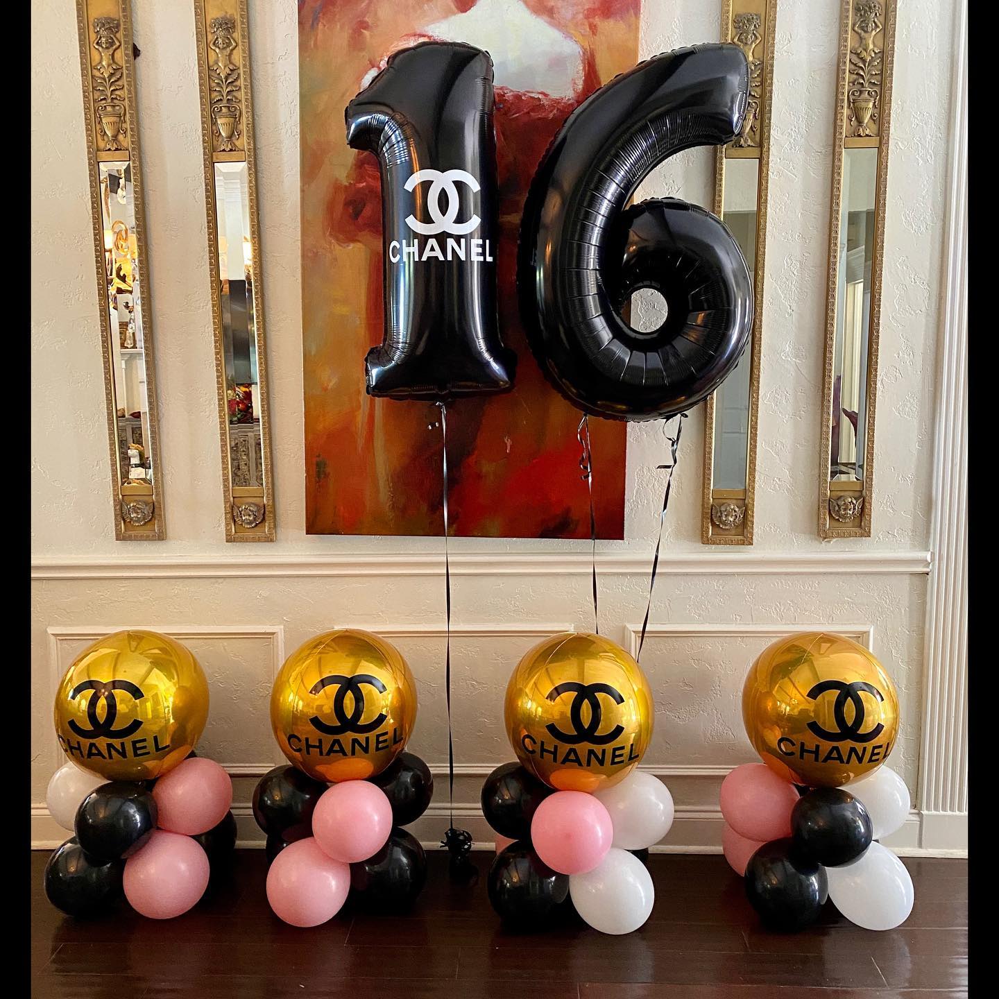 A room with balloons and a painting on the wall.