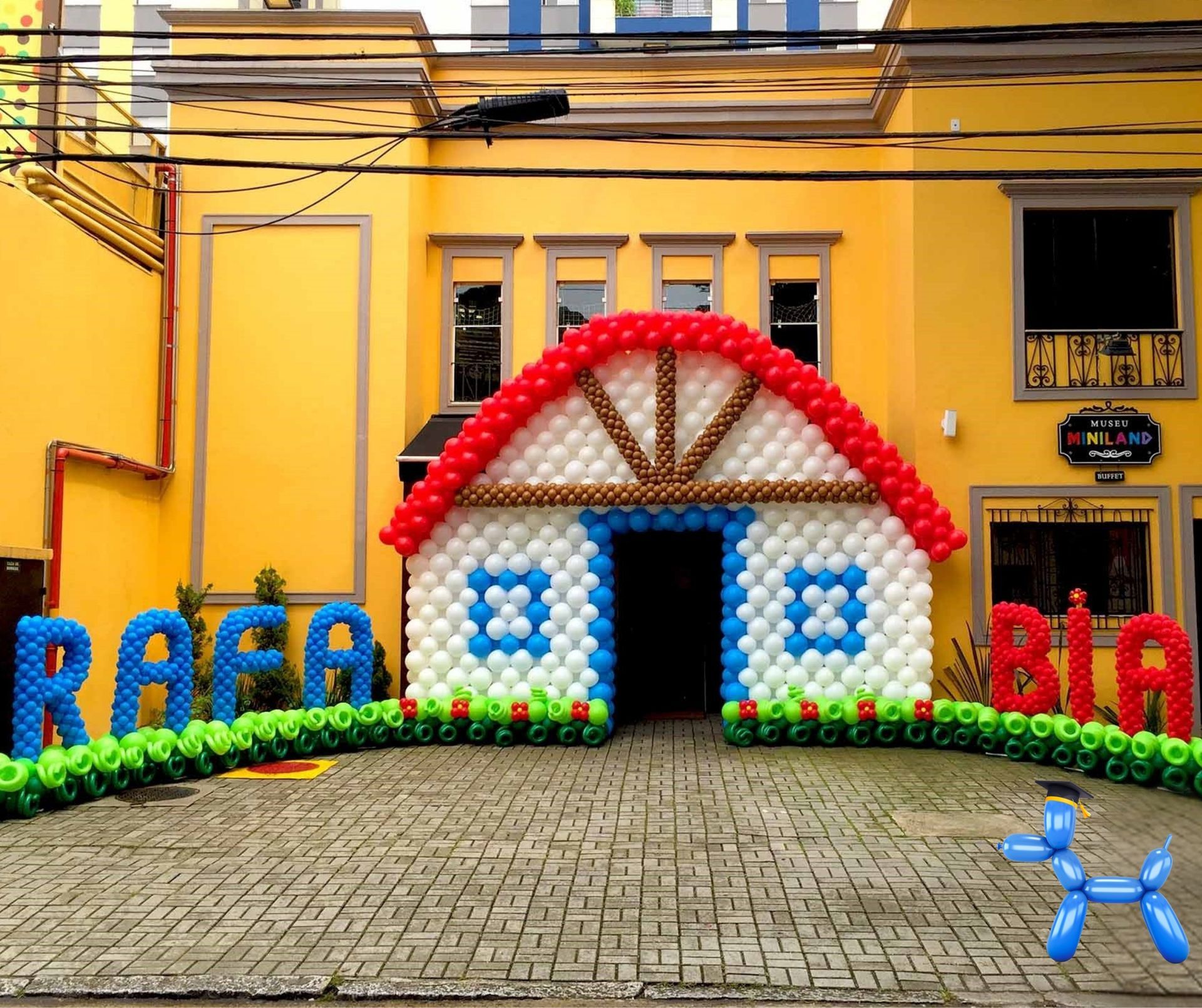 Barn house balloon sculpture in the entrance of a home with the name Rafa made with round balloons in red, white and blue