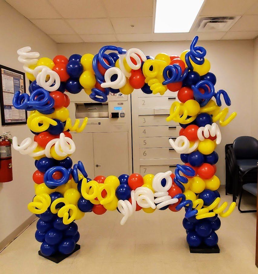 A large arch made of red yellow and blue balloons