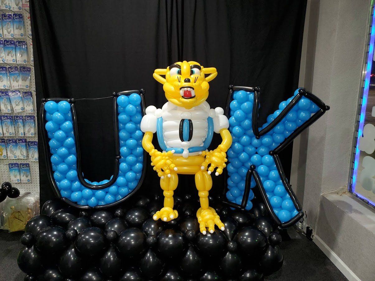 A cheetah made out of balloons is standing in front of a sign that says uk