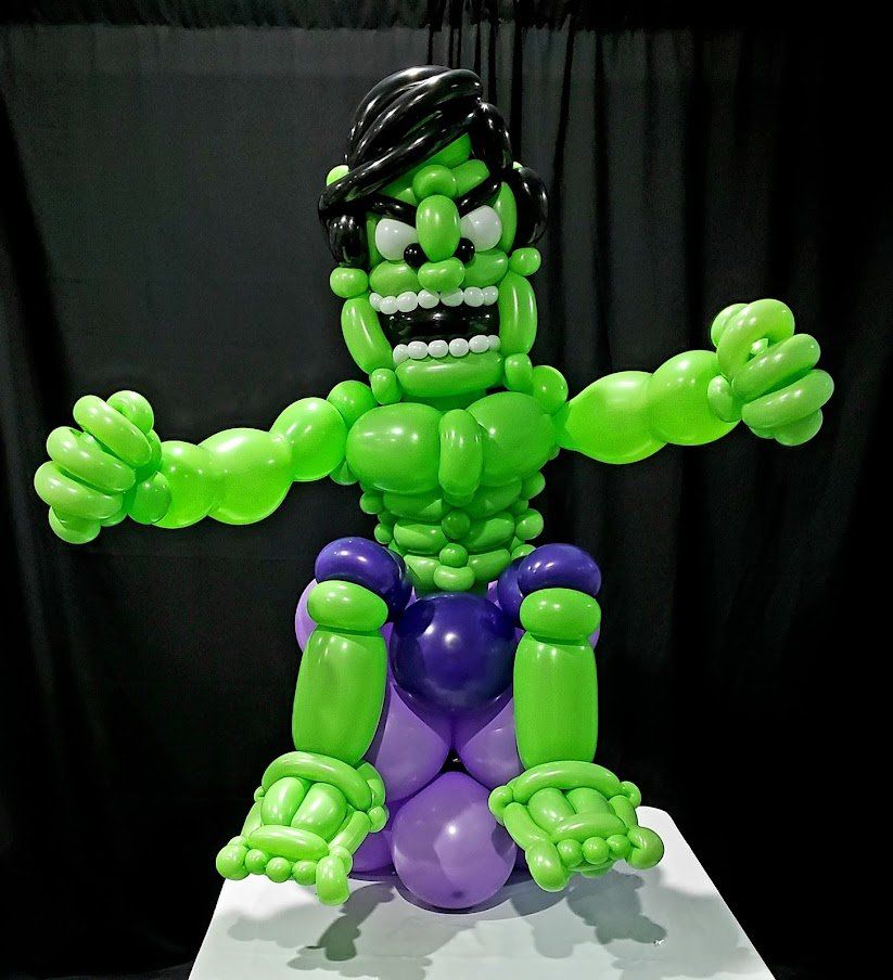 A hulk made out of balloons is sitting on a table.