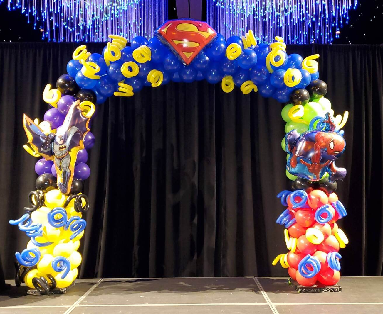 A balloon arch with superman and batman on it