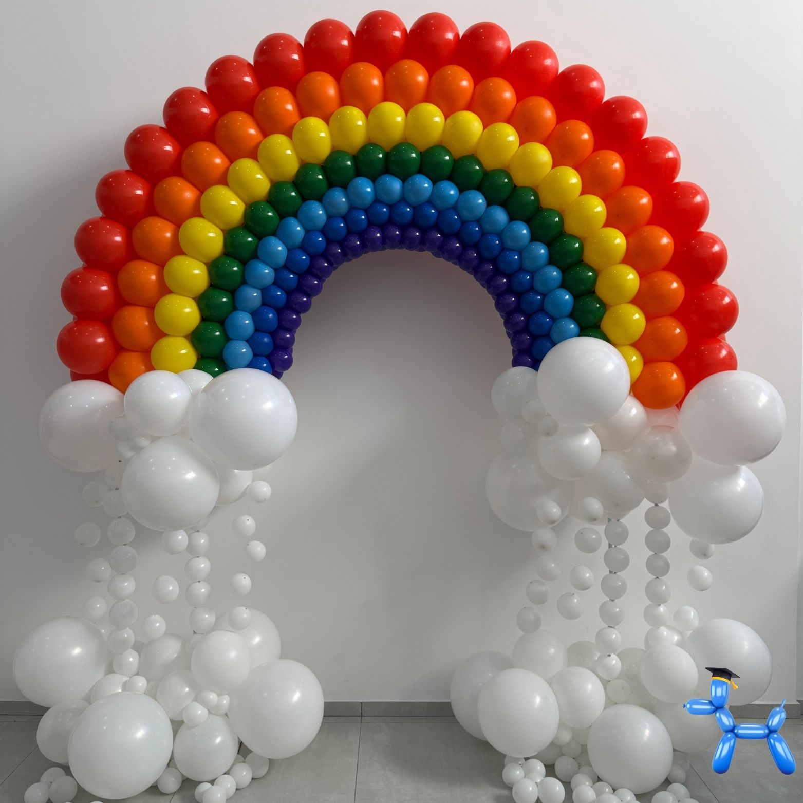 Rainbow themed balloon arch with balloon clouds under it to resemble the arch floating for a baby shower