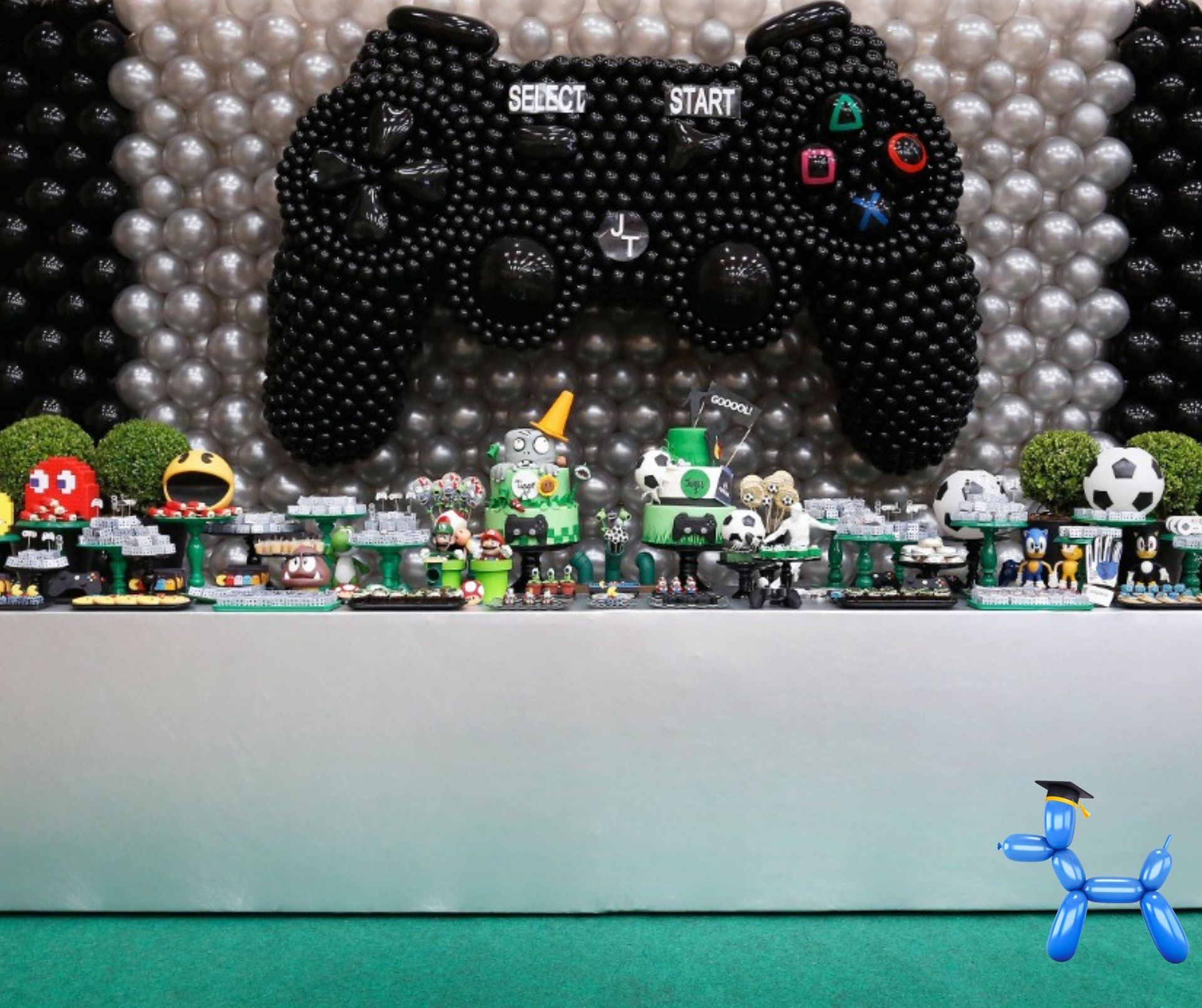Playstation remote control balloon sculpture in black balloons on a silver and black balloon wall