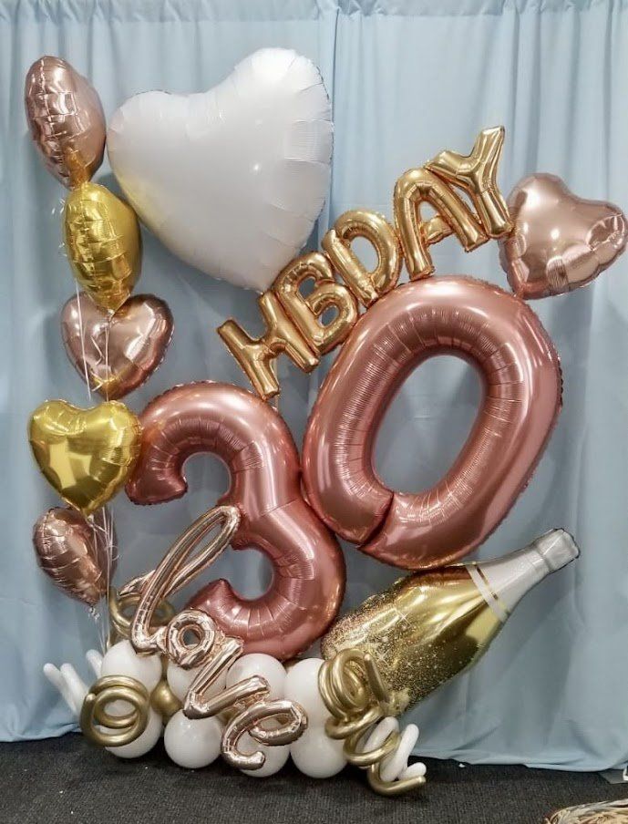 A bunch of balloons with the number 30 on them
