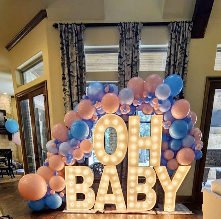 A room with balloons and a sign that says oh baby