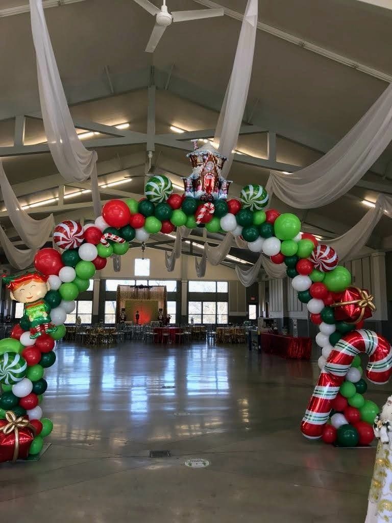 A large room decorated for christmas with balloons and candy canes.