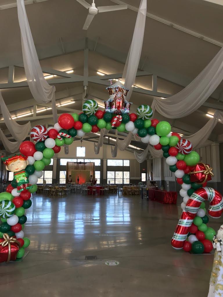A large room decorated for christmas with balloons and candy canes.