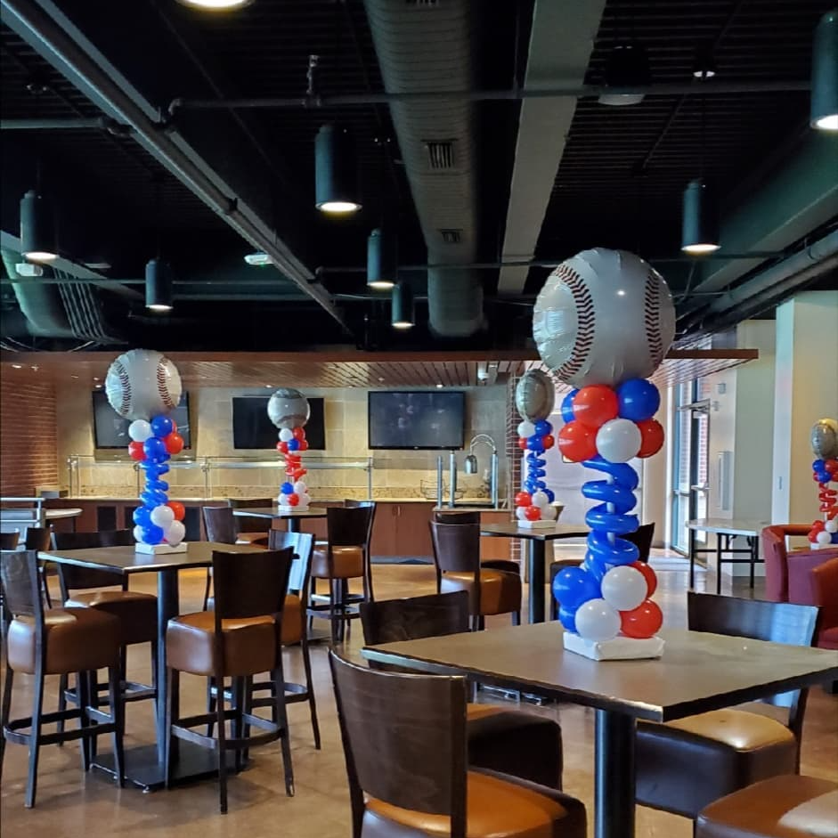 A restaurant with tables and chairs decorated with red white and blue balloons