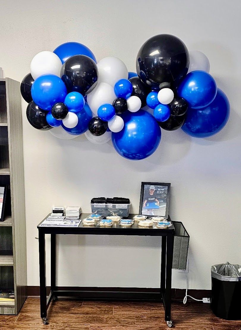 A living room with a couch and balloons on the wall.