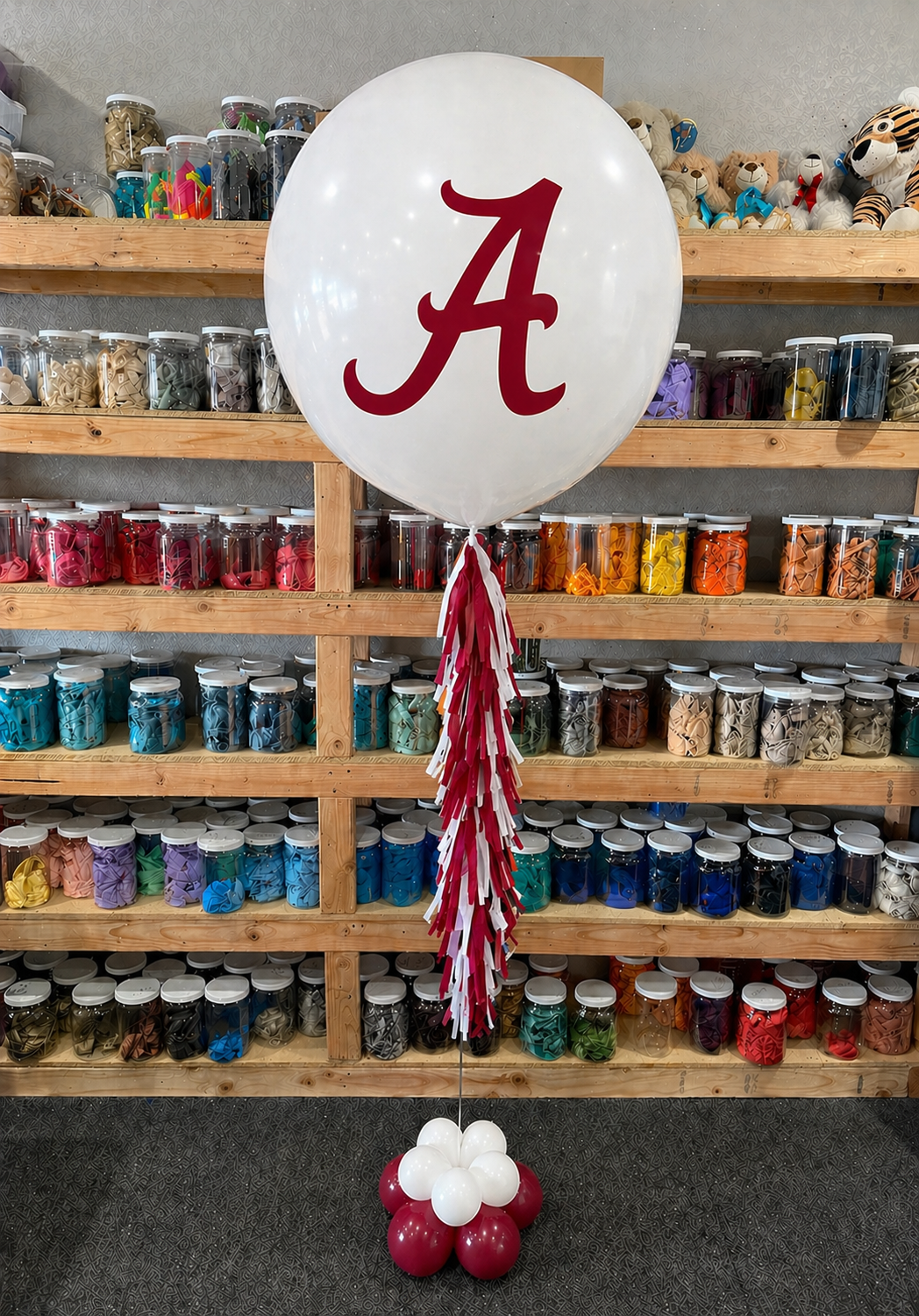 A jumbo helium balloon personalized with College logo and color, with matching colored tassels..