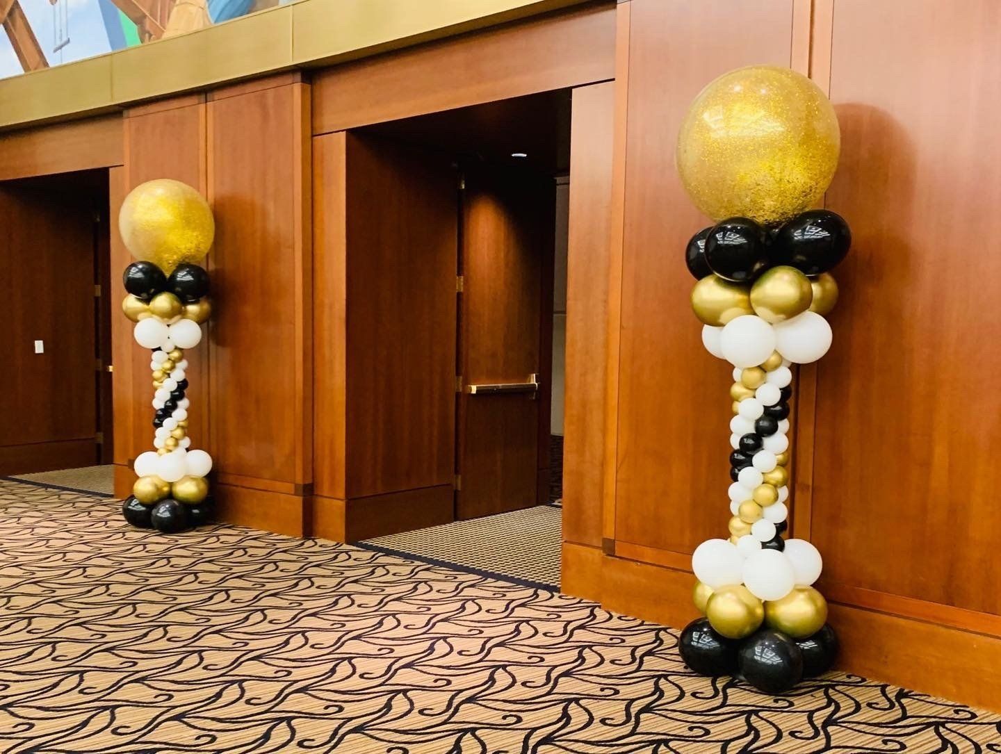There are two columns made of balloons in a hallway.