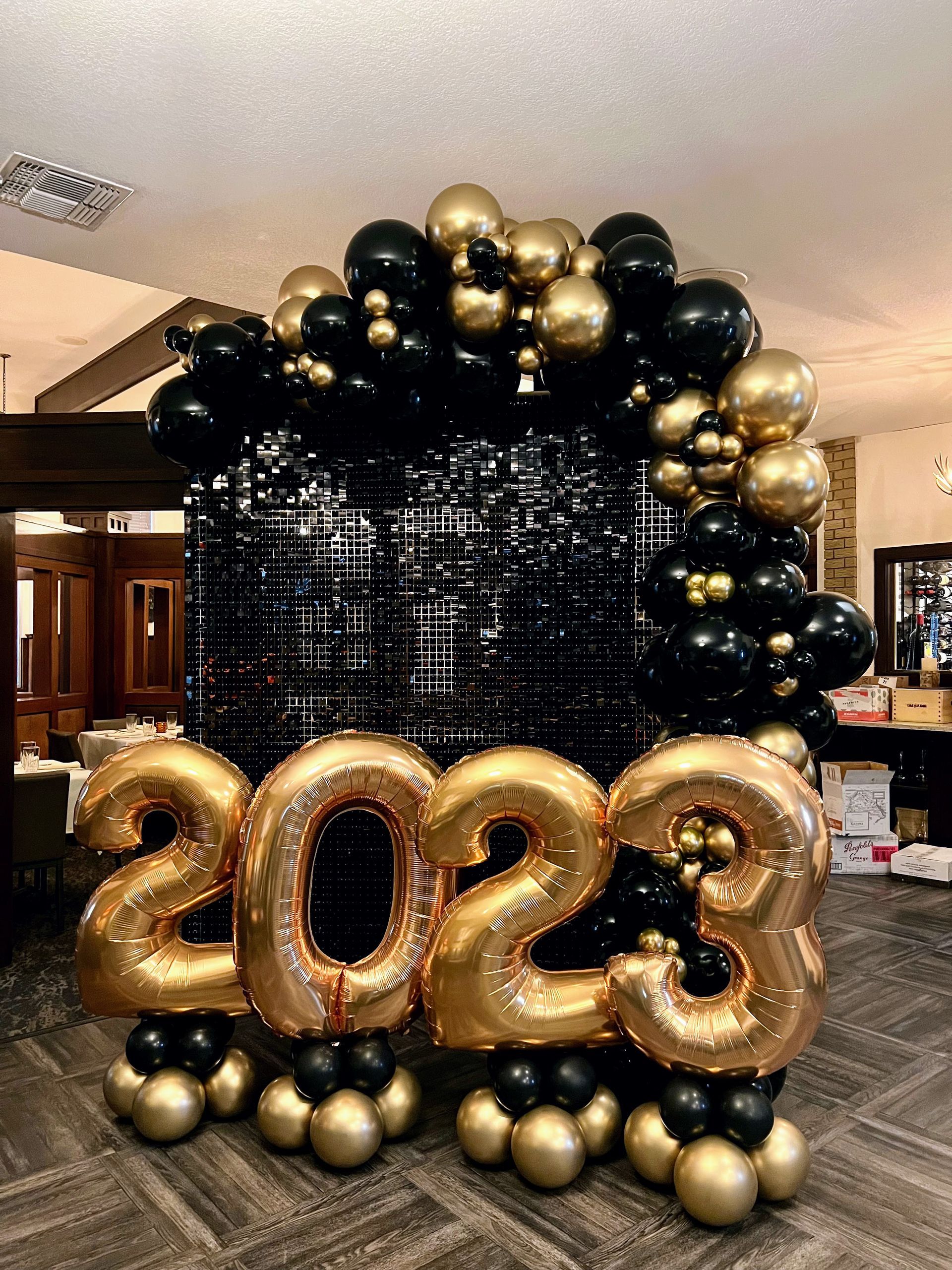 A room filled with balloons and a sign that says 2023.