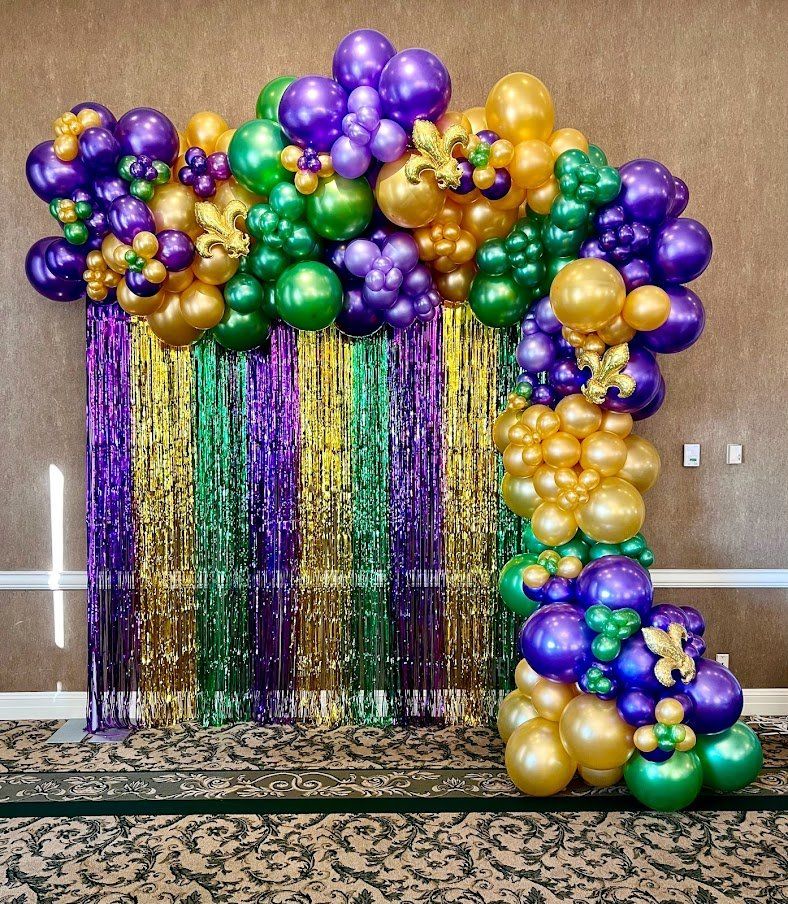 A bunch of balloons are sitting in front of a wall.