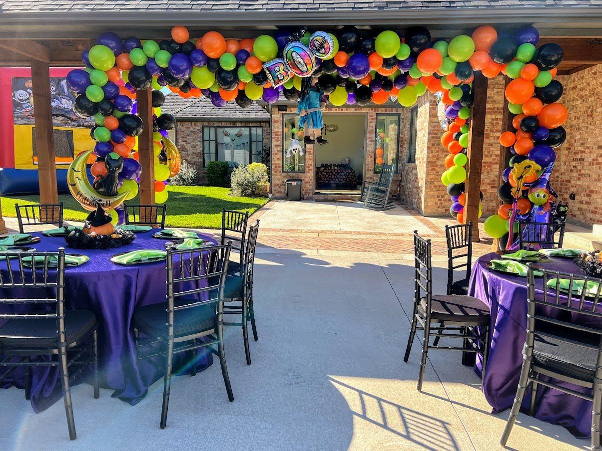 A patio with tables and chairs decorated for a halloween party.