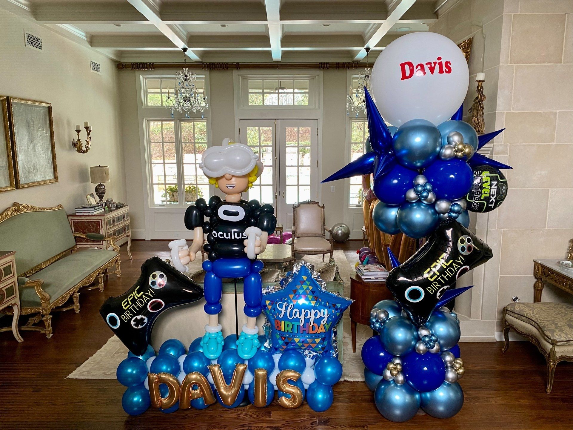 A room filled with balloons and a statue of a man.