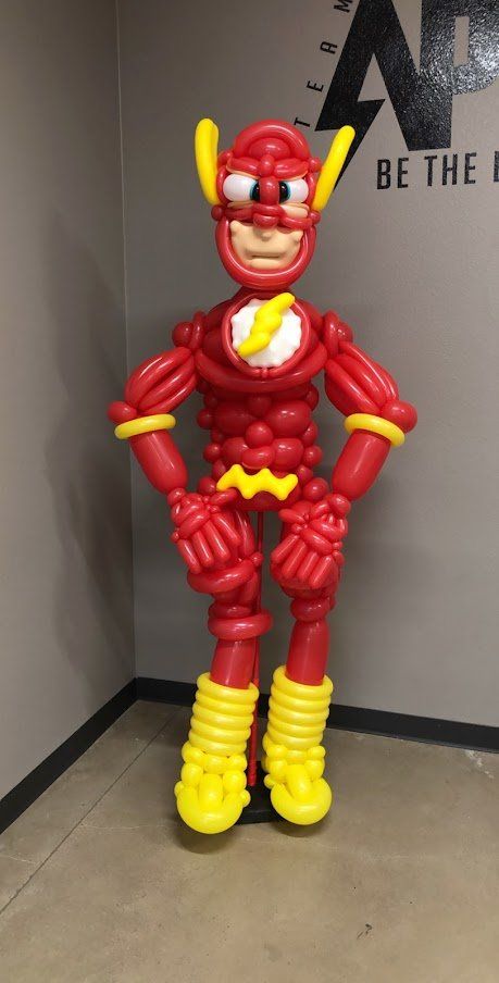 A balloon figure of the flash is standing in a room