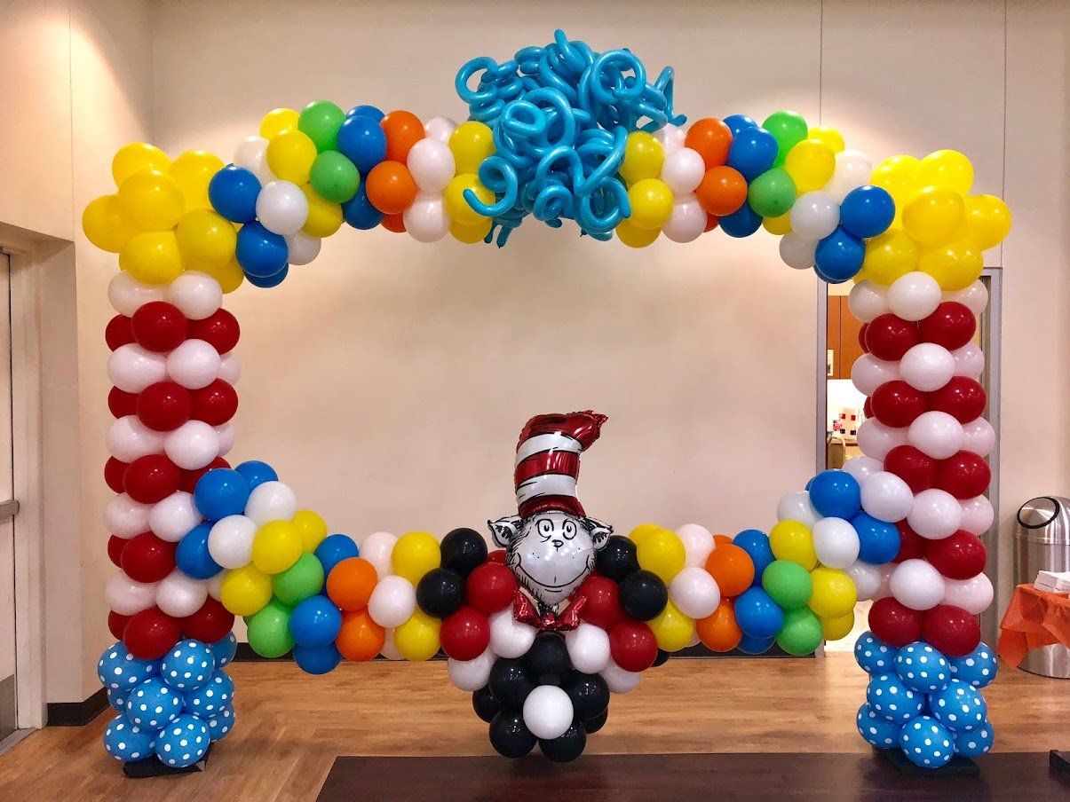 A cat in the hat balloon is surrounded by colorful balloons