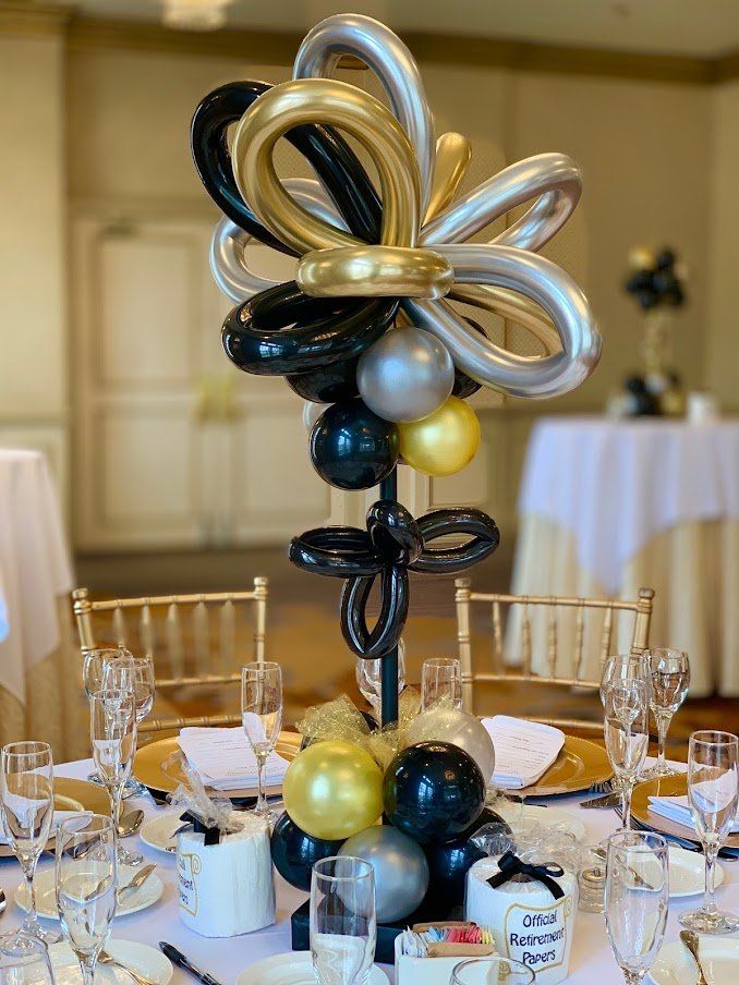 A table with plates , glasses , and balloons on it.