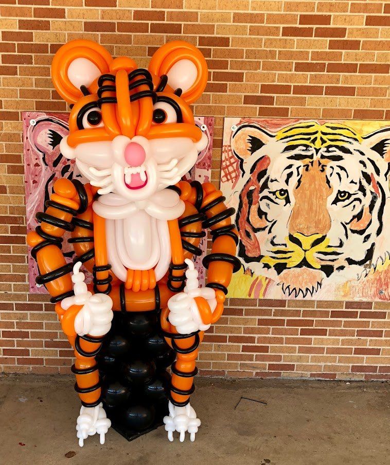 A statue of a tiger made out of balloons giving a thumbs up