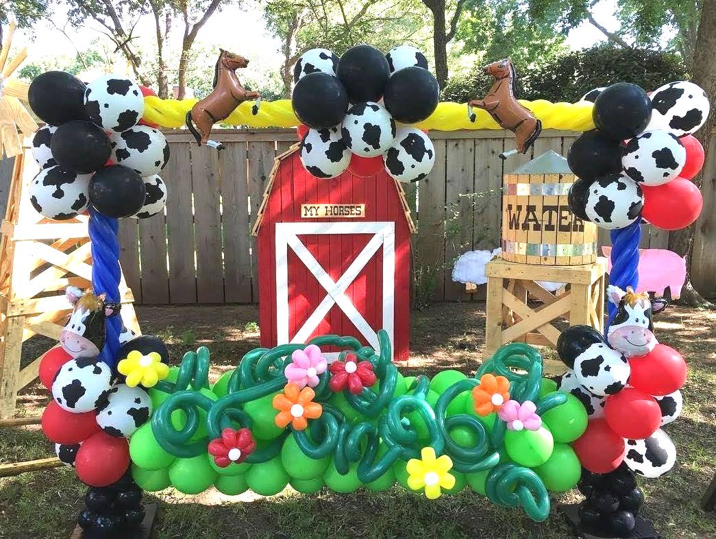 A barn decorated with balloons and cow print balloons for a cowboy themed birthday party.