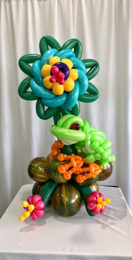 A frog made out of balloons is sitting on top of a table.