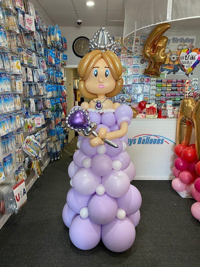 A princess made out of balloons is standing in a store.