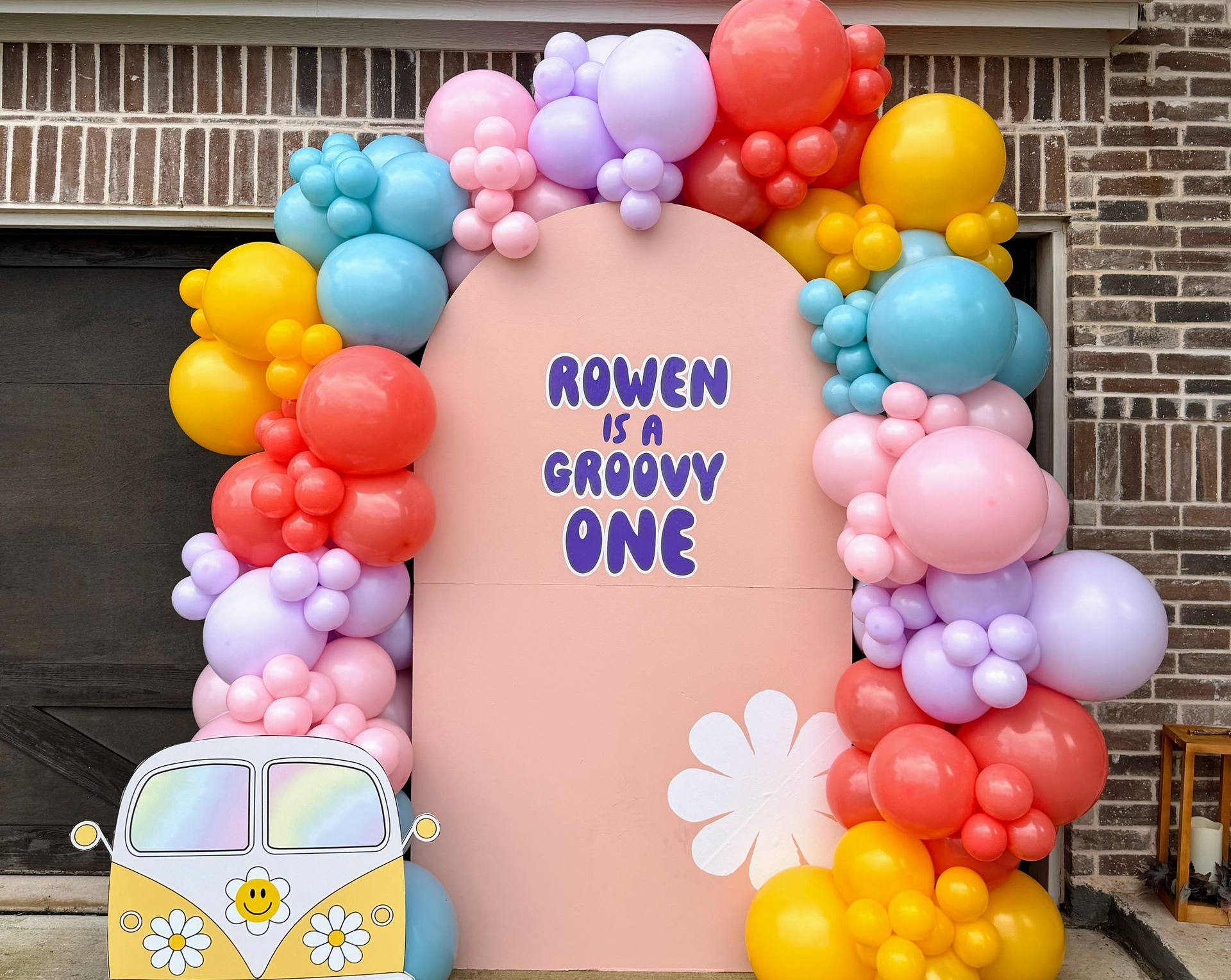 a colorful organic balloon garland with a backdrop for a party in fort worth, tx
