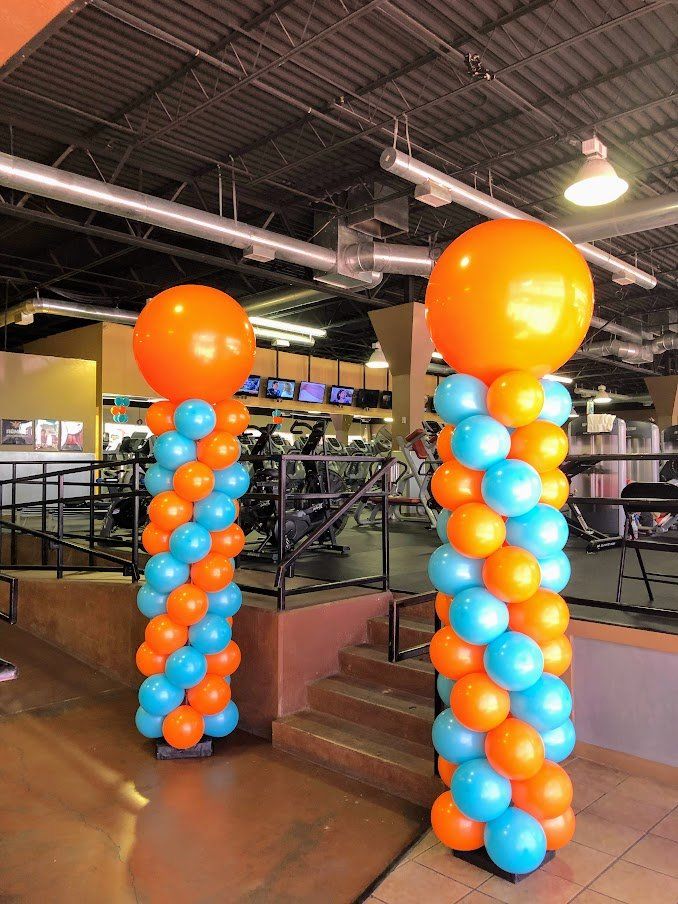Two columns of orange and blue balloons in a gym