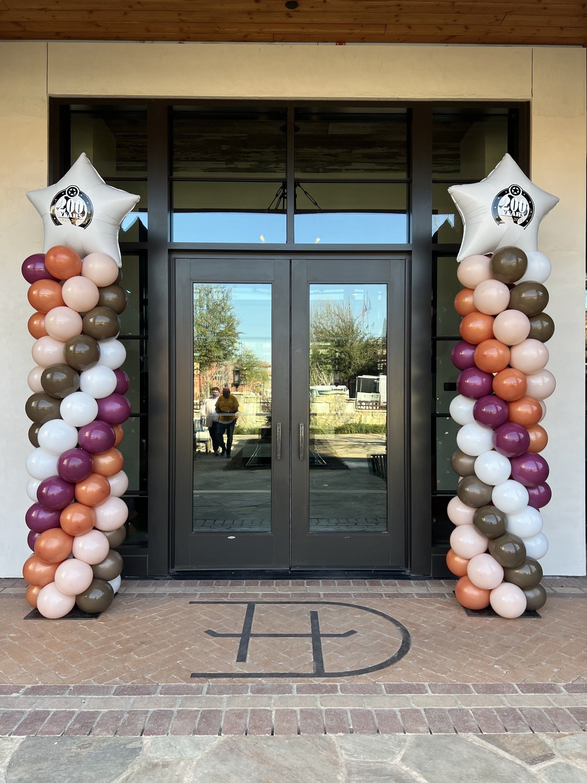 A row of balloons are lined up in front of a building.