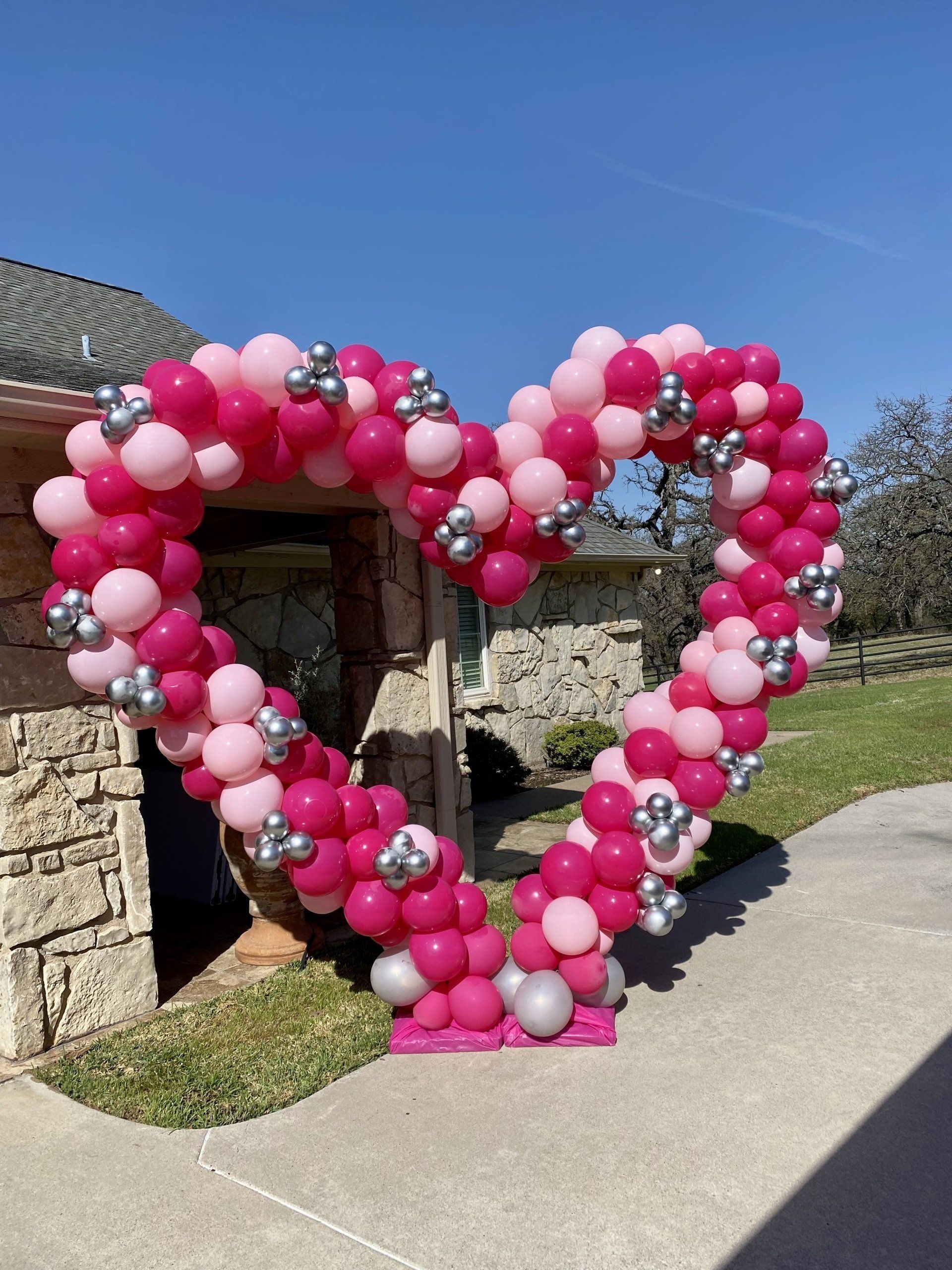 A large heart made of pink and silver balloons