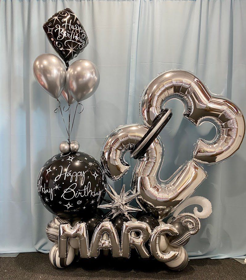 A bunch of balloons with the name marc on them.