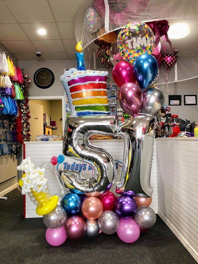 A bunch of balloons are sitting on a table in a room.