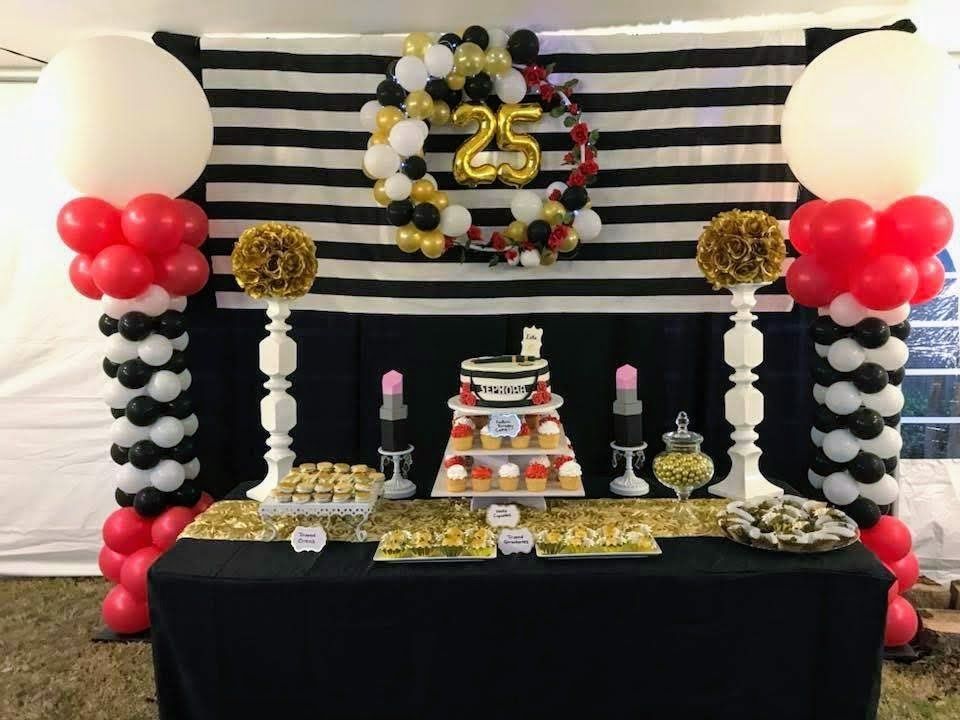 A table decorated with balloons and a cake for a 25th birthday.