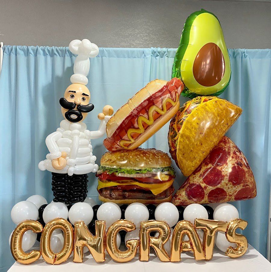 A bunch of food balloons are sitting on top of each other on a table.