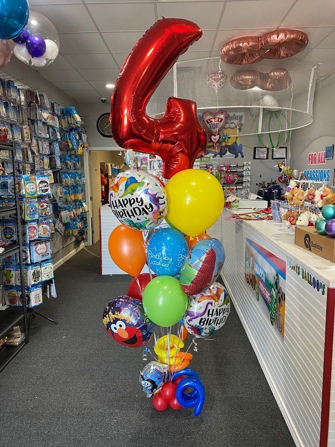 A bunch of balloons in a store with a red number 4 in the middle