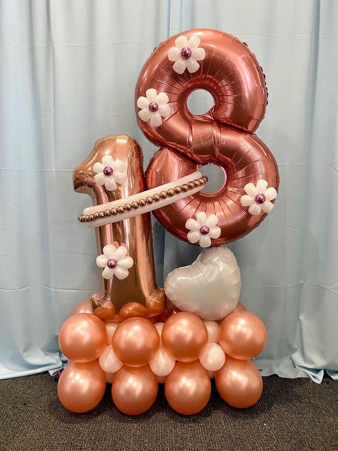A bunch of balloons with the number 18 on top of them.