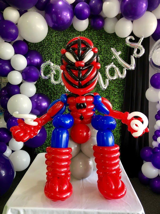A spiderman made out of balloons is sitting on a table