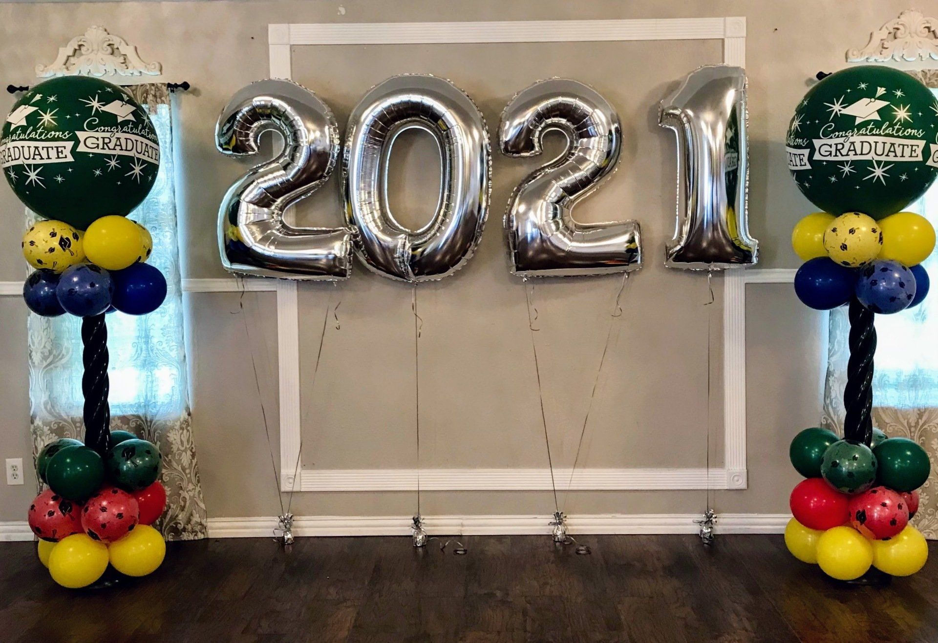A room decorated with balloons and a sign that says 2021