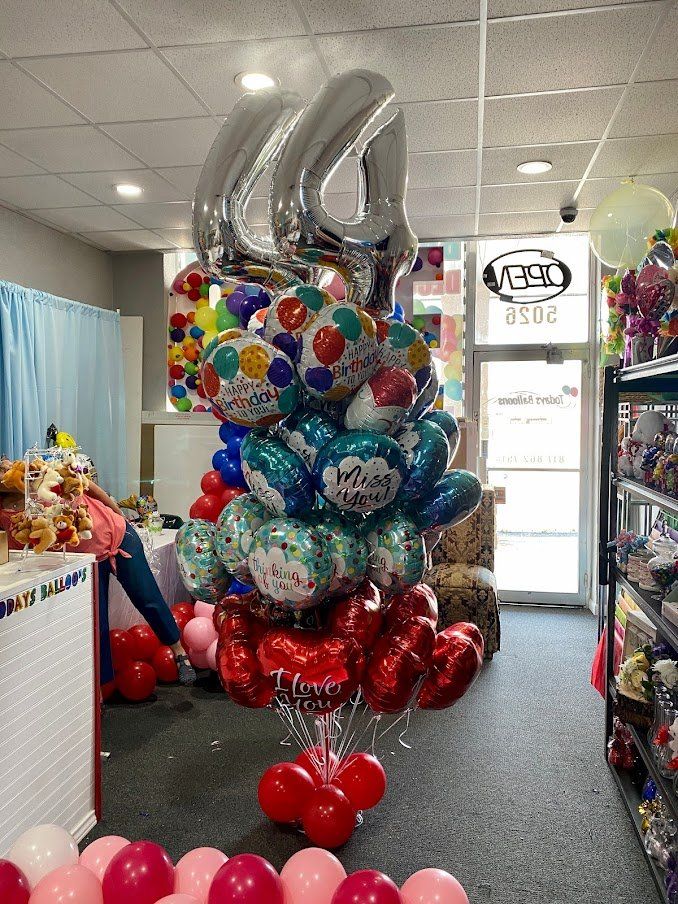 A bunch of balloons are stacked on top of each other in a store.