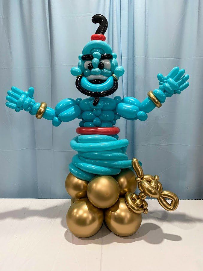 A genie made out of balloons is sitting on a table.