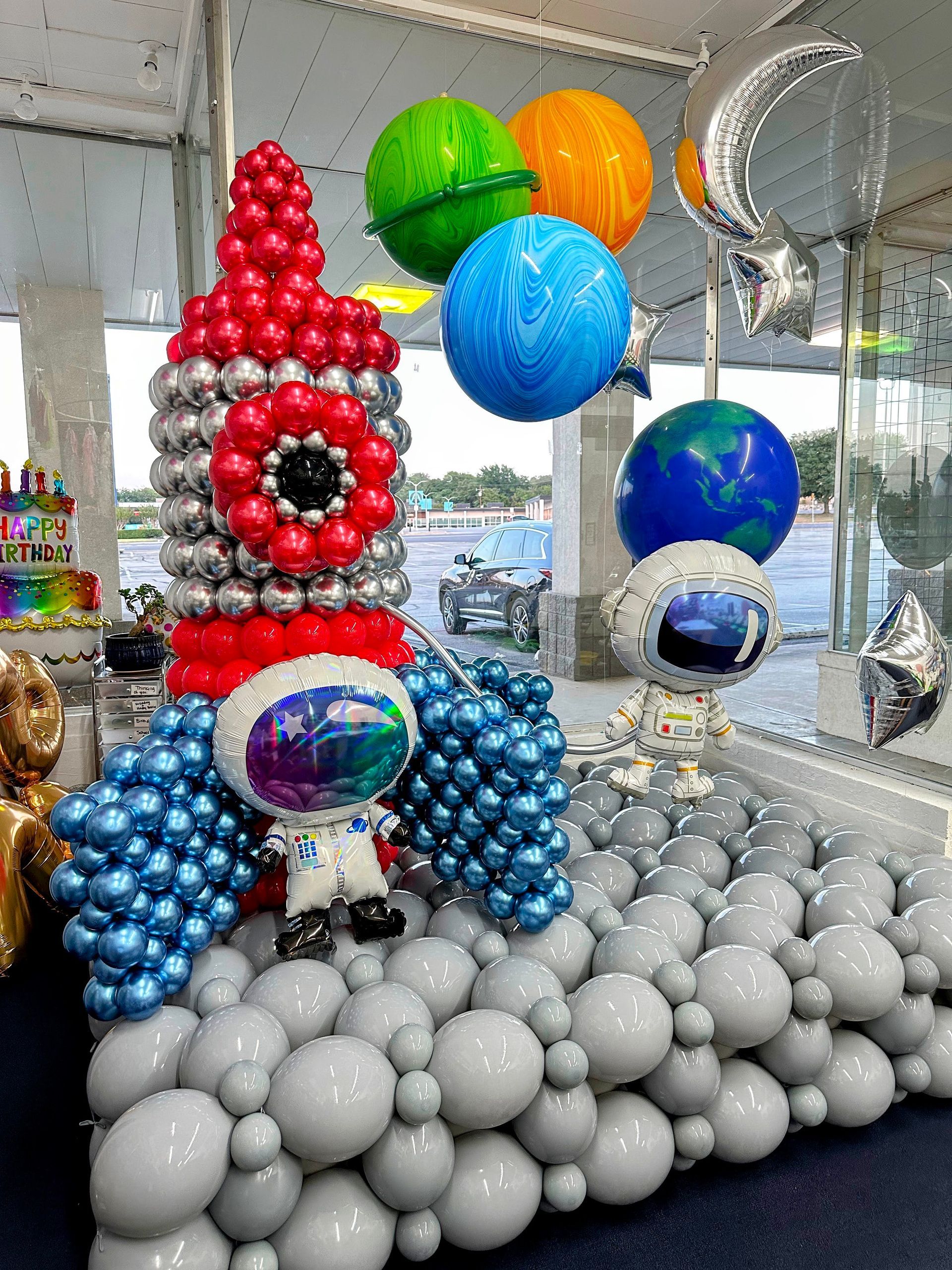A rocket made out of balloons is sitting on top of a pile of balloons.
