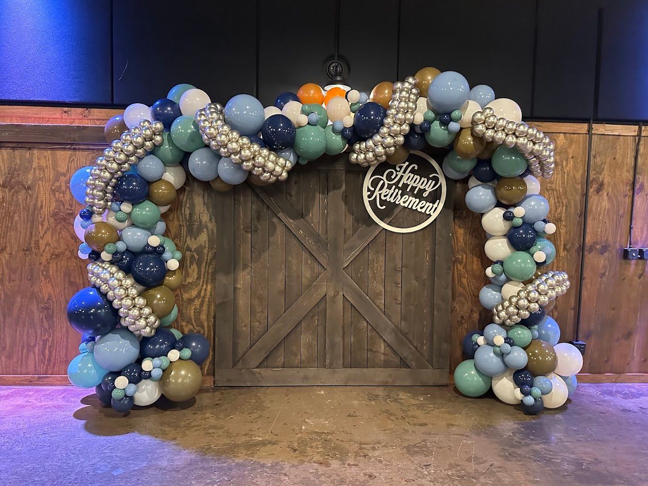 A wooden door is decorated with balloons and a sign.