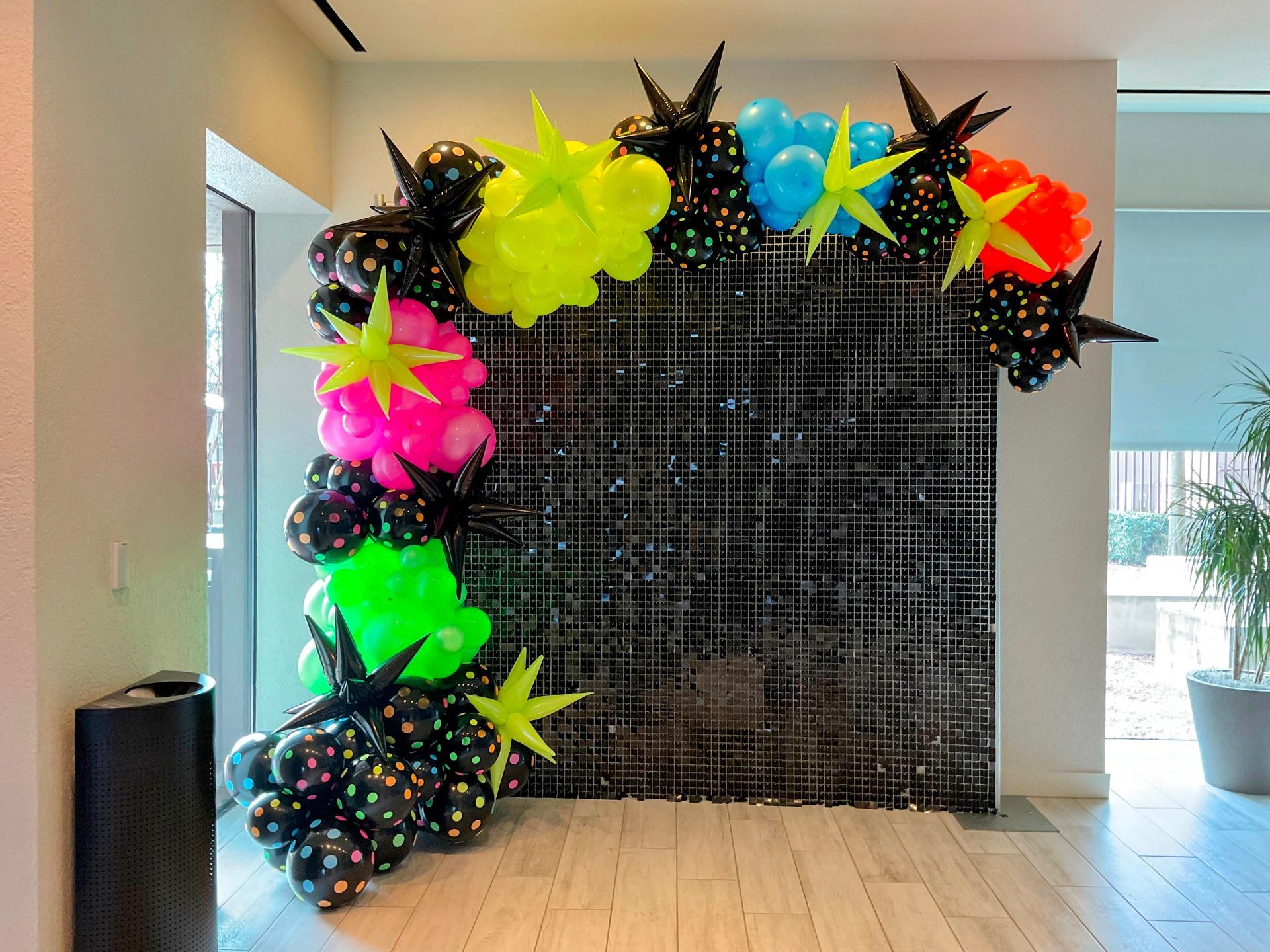 A wall with balloons and stars on it in a room.