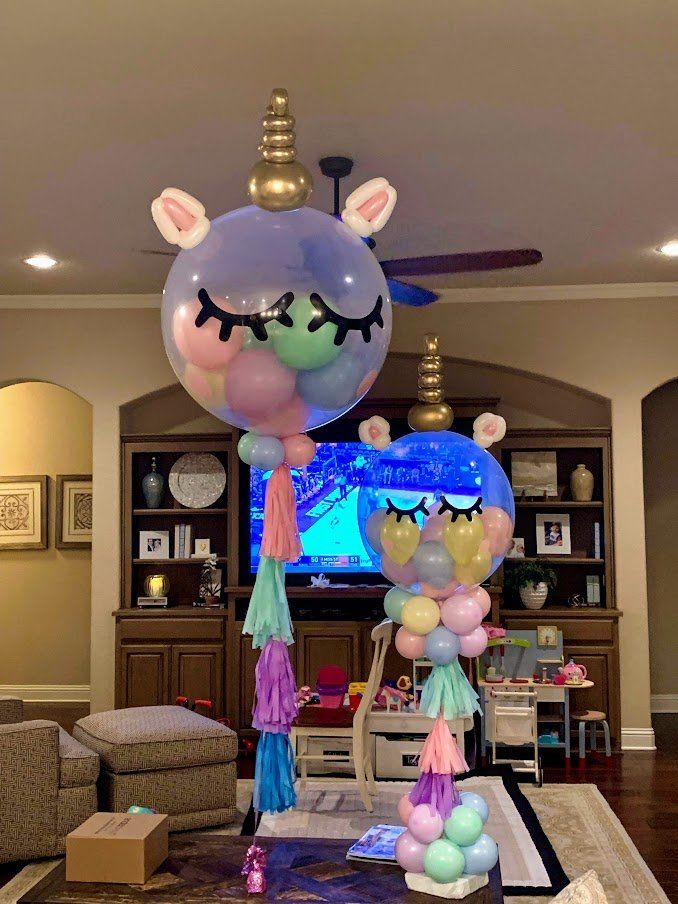 A living room decorated with balloons in the shape of a unicorn.