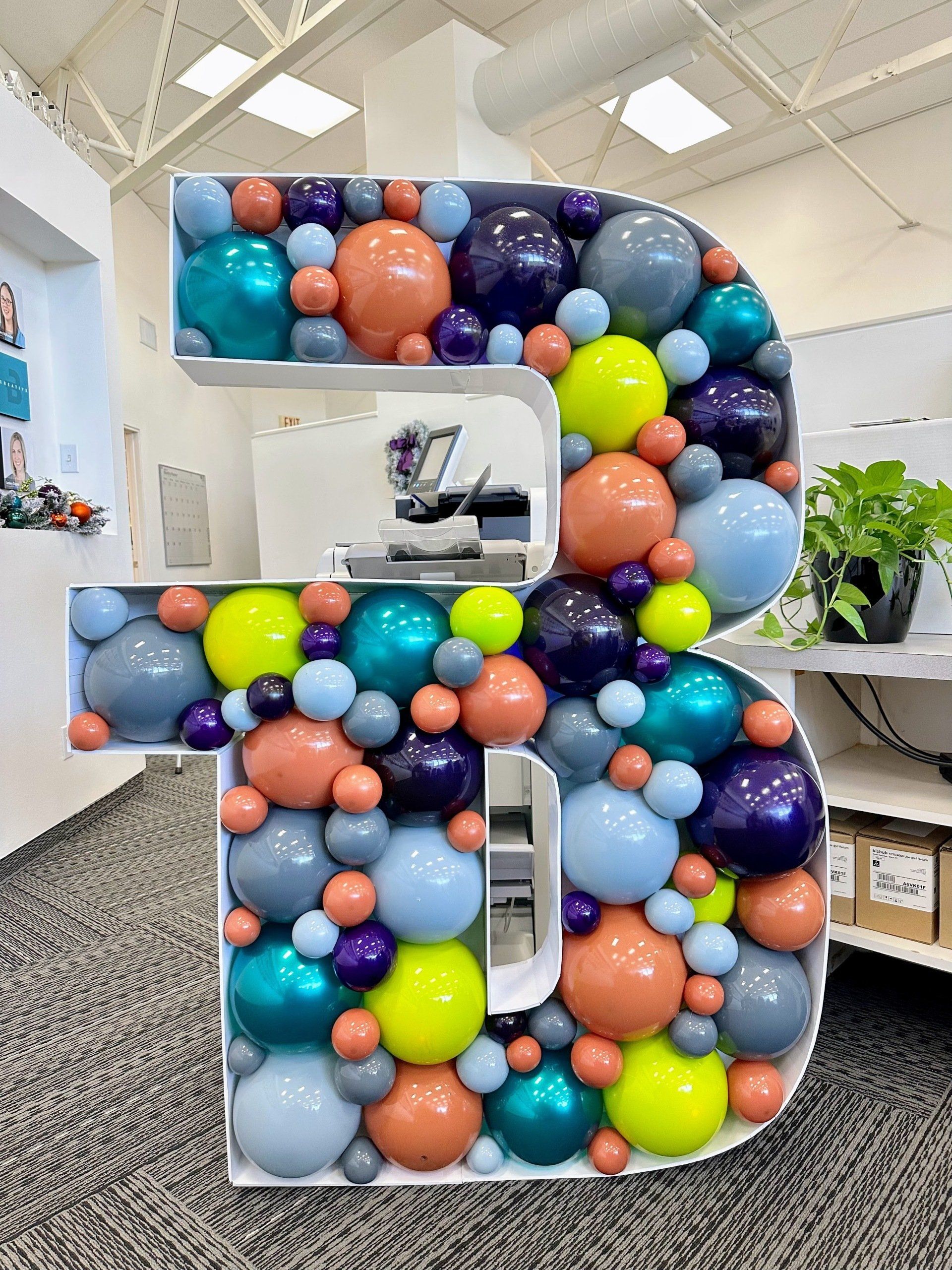 A large letter b made of balloons in a room.